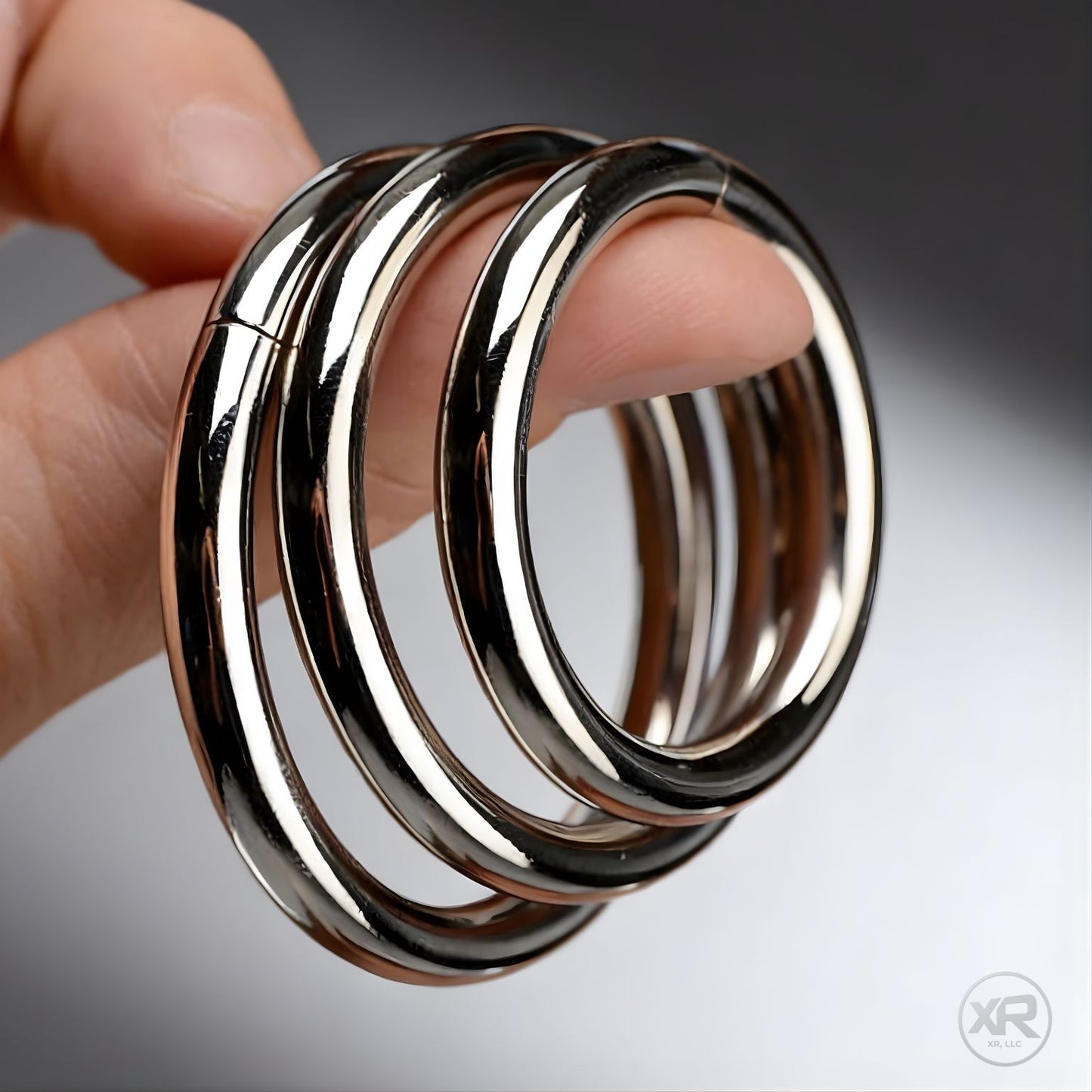 set of polished steel cock rings for gay men shown in hand highlighting solid weight and smooth rounded edges