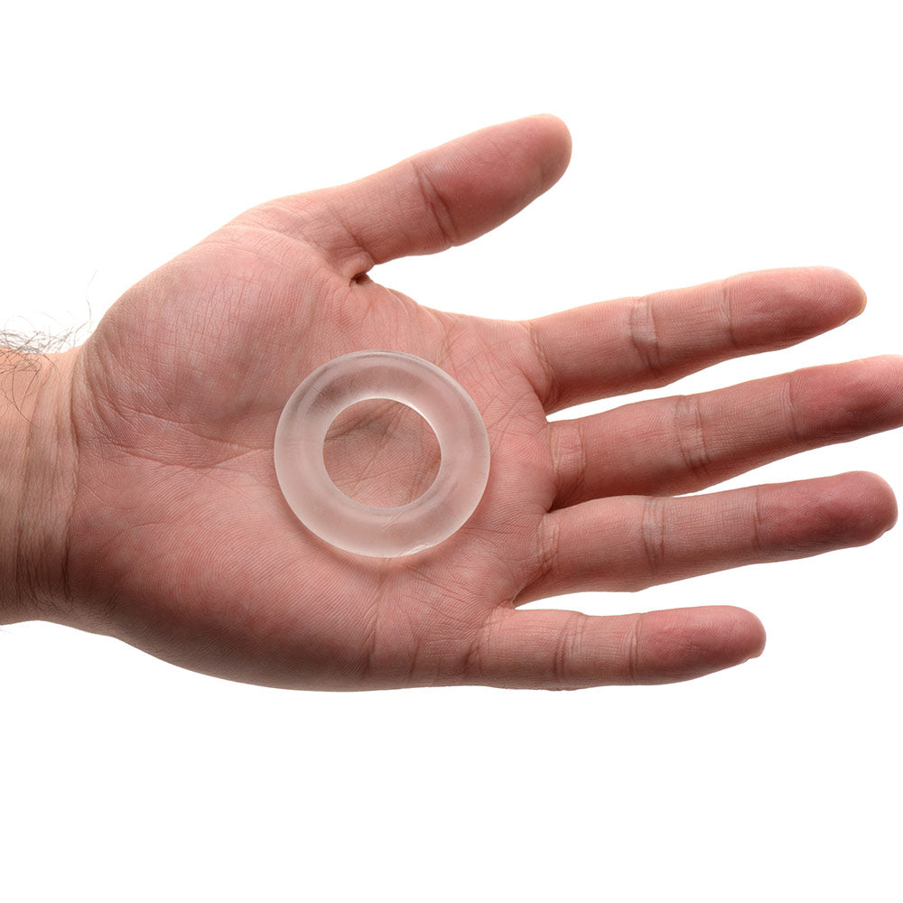 Super Stretch Universal Cock Ring resting in an open hand to demonstrate its compact size, clear flexible material, and thick comfort-fit design for men’s enhancement and support