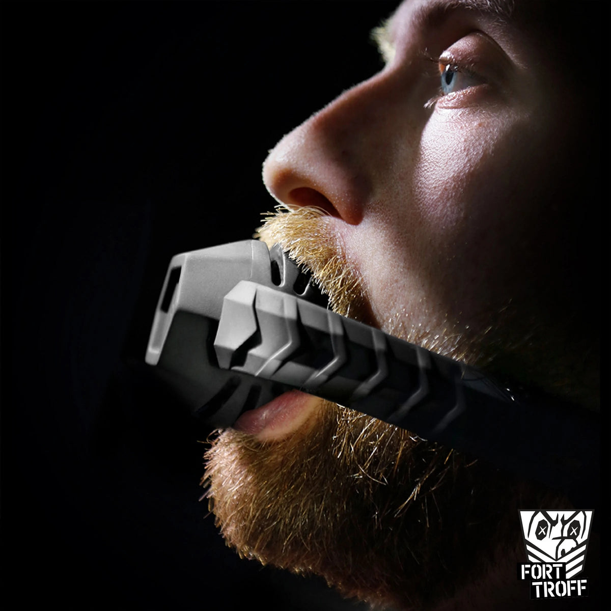Bearded man gagged with the Max Comfort silicone ball gag, side profile, Fort Troff gay gear at Boyzshop