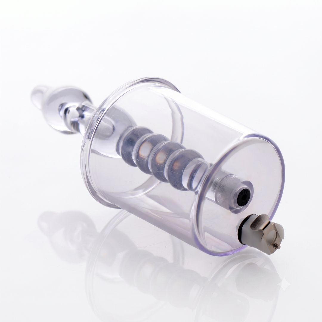Rear angled view of a transparent anal pump cylinder highlighting the vacuum port, air-release valve, and internal textured stimulation shaft.