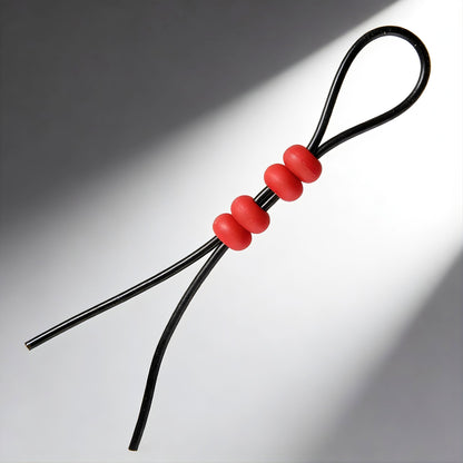 close up of adjustable black cord cock ring with red sliding beads for customizable fit
