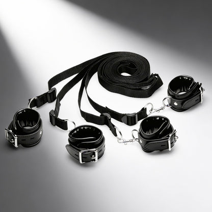 complete black faux leather bed restraint system with four padded cuffs and adjustable under-bed straps