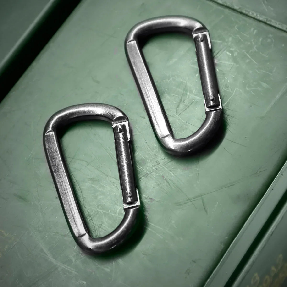 2 steel carabiner clips for bondage restraints on an olive ammo box, Fort Troff gay gear at Boyzshop