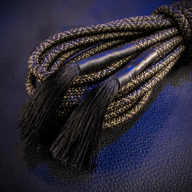 Close-up of the black tasseled ends on a coiled hank of Grunt Rope shibari rope, Fort Troff gay gear at Boyzshop