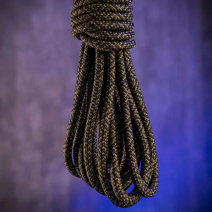Grunt Rope olive shibari rope hanging in a loose coil against a purple backdrop, Fort Troff gay gear at Boyzshop