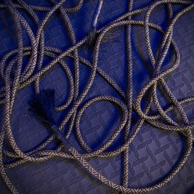 Grunt Rope bondage rope looped loose on a blue floor with a tassel end showing, Fort Troff gay gear at Boyzshop