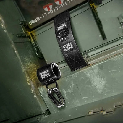 Pair of Neo neoprene wrist restraints with a carabiner resting on an olive ammo can, Fort Troff gay gear at Boyzshop