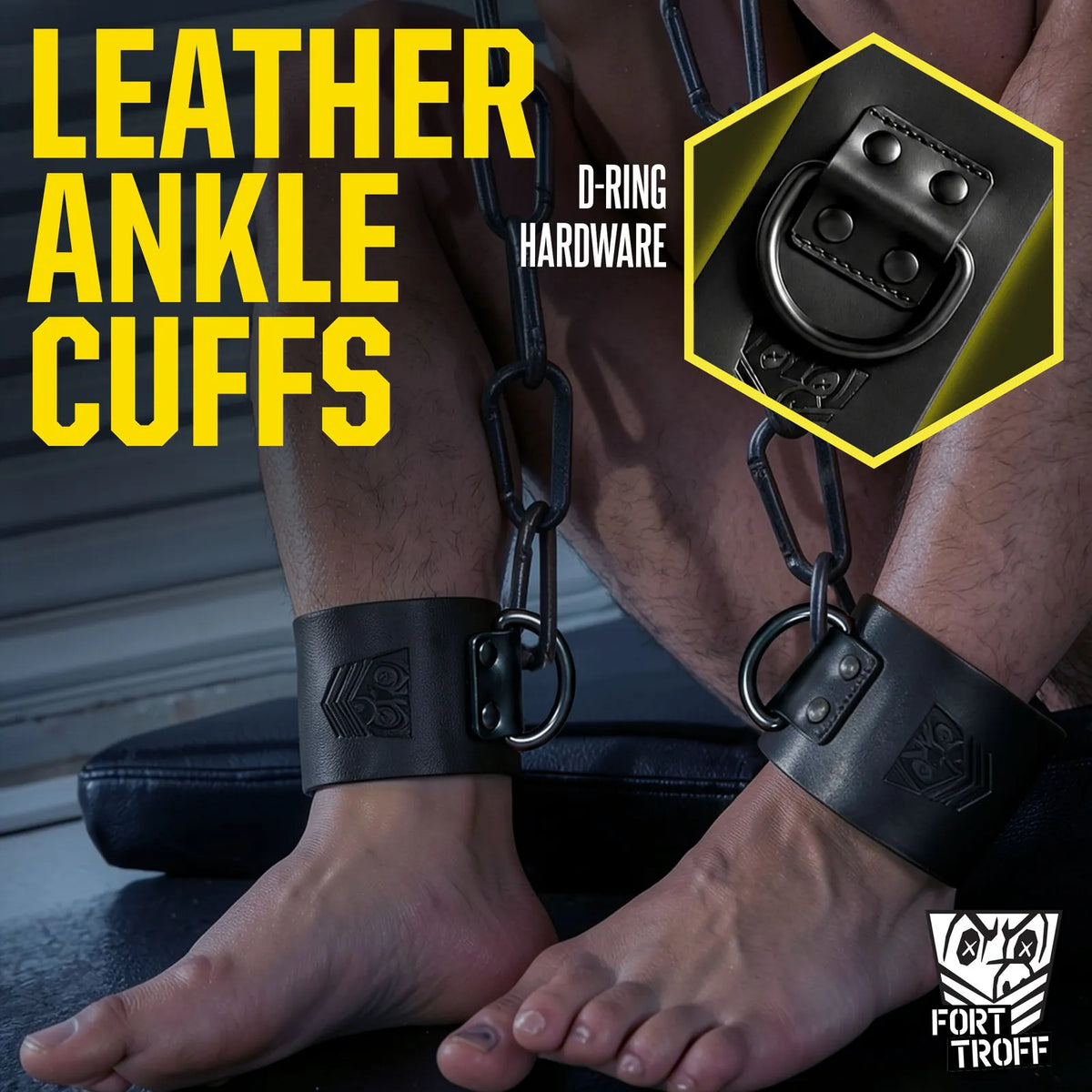 Leather ankle cuffs worn on bare ankles chained to a frame, D-ring hardware inset graphic, Fort Troff gay gear at Boyzshop