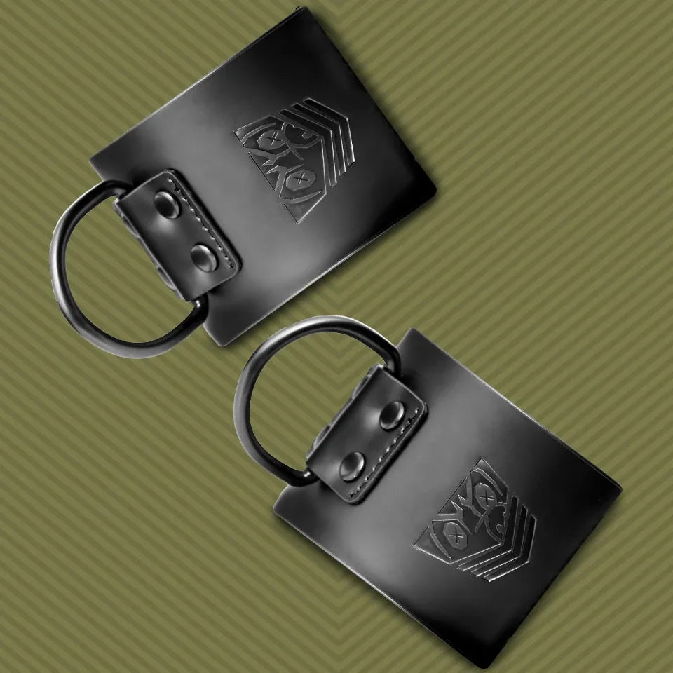 Close-up of 2 leather ankle cuffs with dark D-rings plus embossed Fort Troff shield on olive, Fort Troff gay gear at Boyzshop