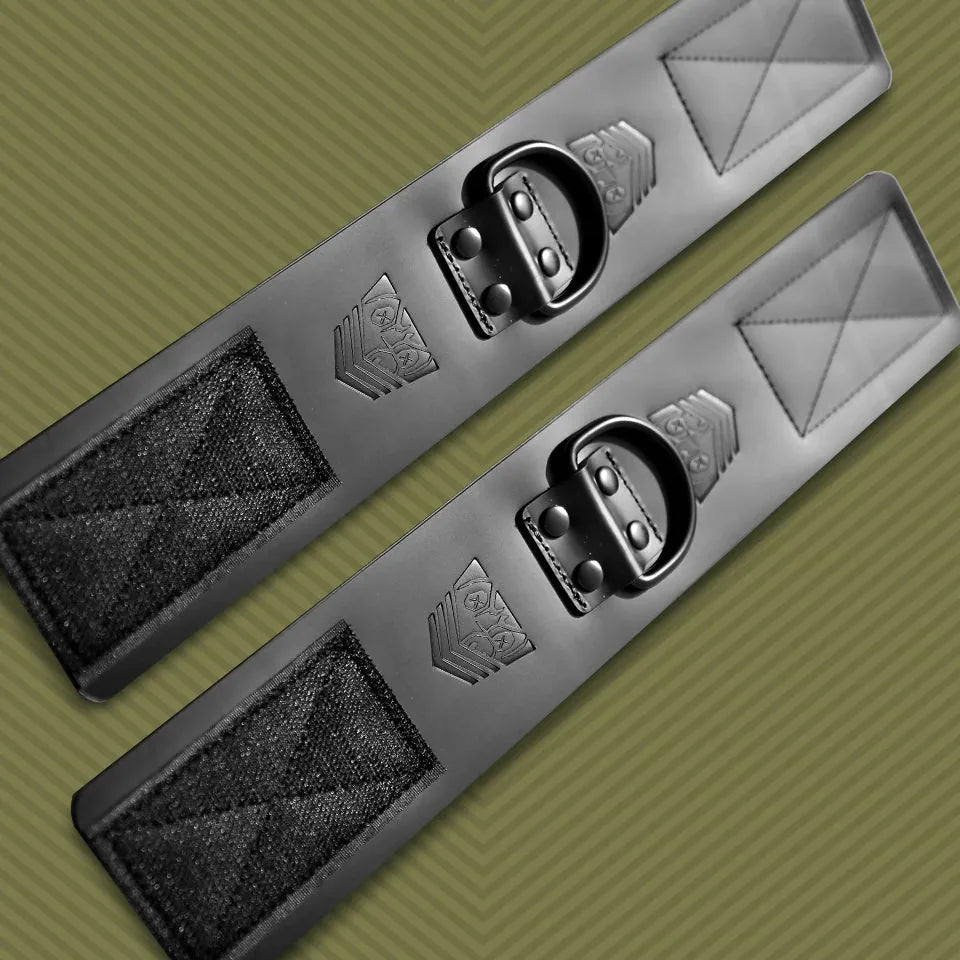 Leather ankle cuffs pair laid flat at an angle on olive, Velcro panels at each end, Fort Troff gay gear at Boyzshop