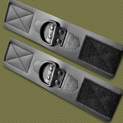 Leather bondage ankle cuffs side by side on olive, D-rings centered between Velcro panels, Fort Troff gay gear at Boyzshop