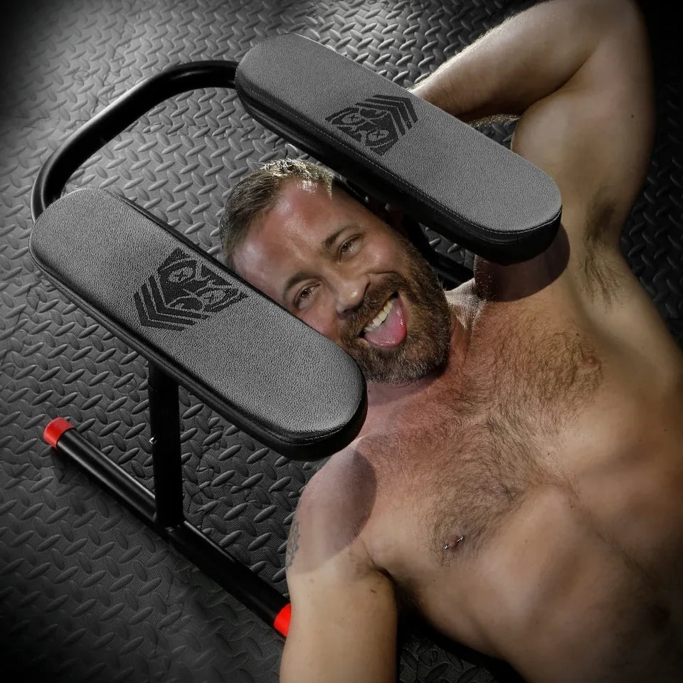Grinning bearded man lying under the Ready Rimmer rimming chair, Fort Troff gay gear at Boyzshop