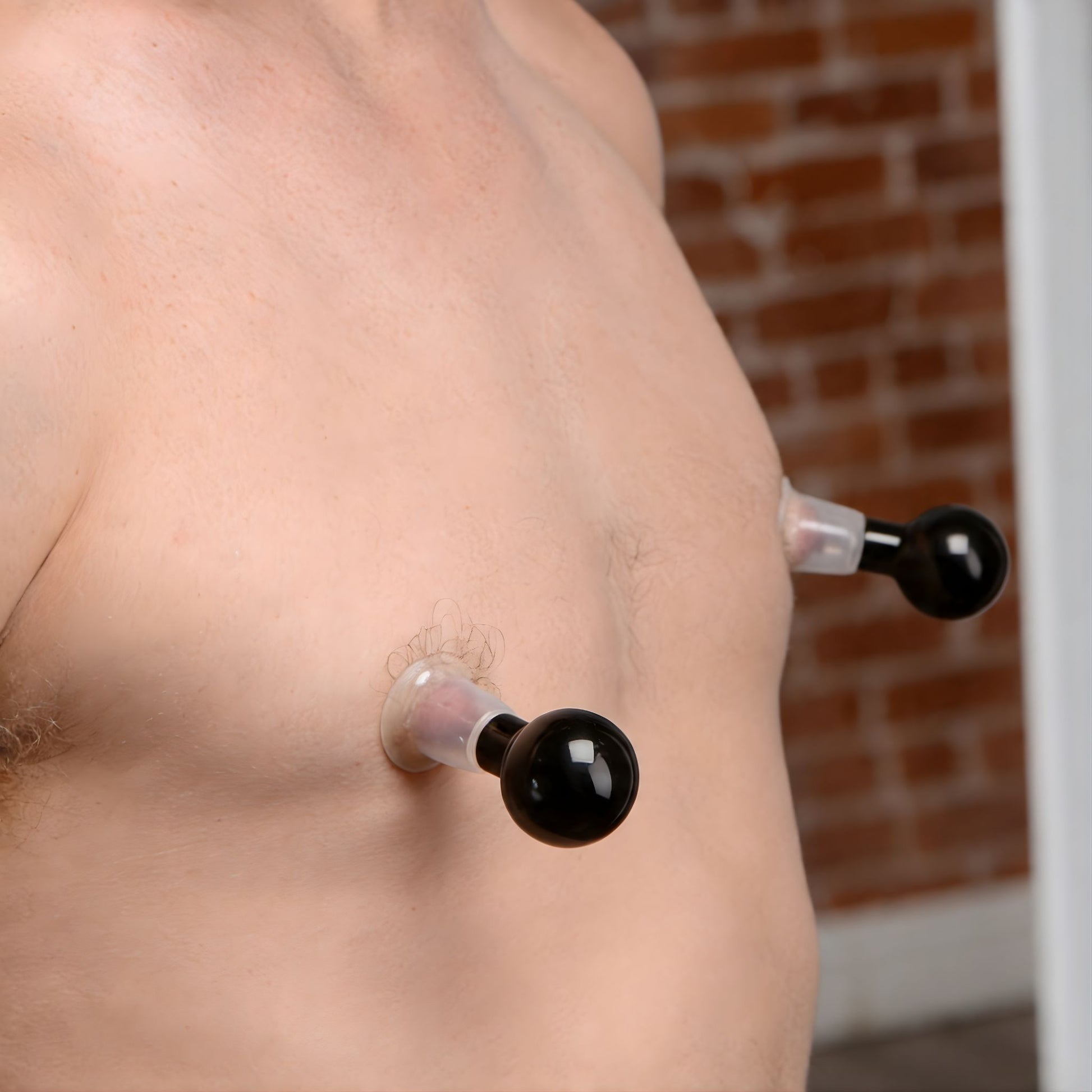 clear nipple suckers creating vacuum suction on male chest to enhance nipple sensitivity