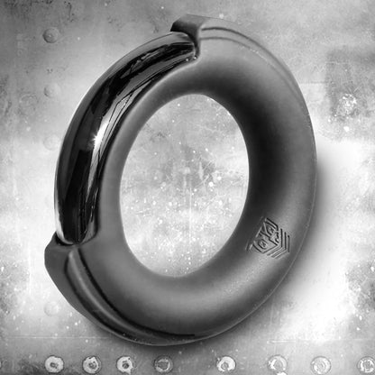 Pinch Zero silicone-cased chrome cock ring on a riveted steel background
