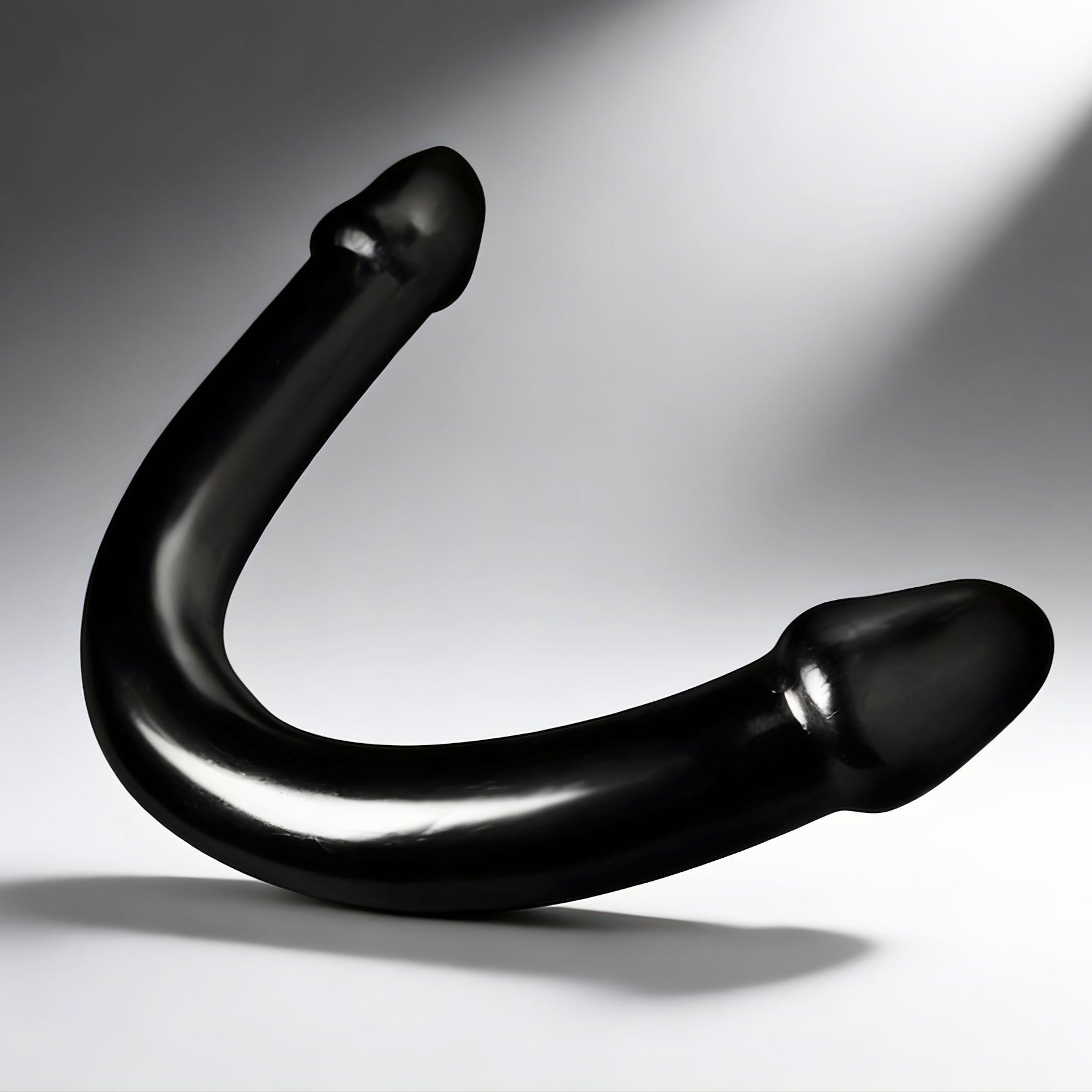 black XL double ended curved dildo with smooth finish and bulbous tips on neutral background