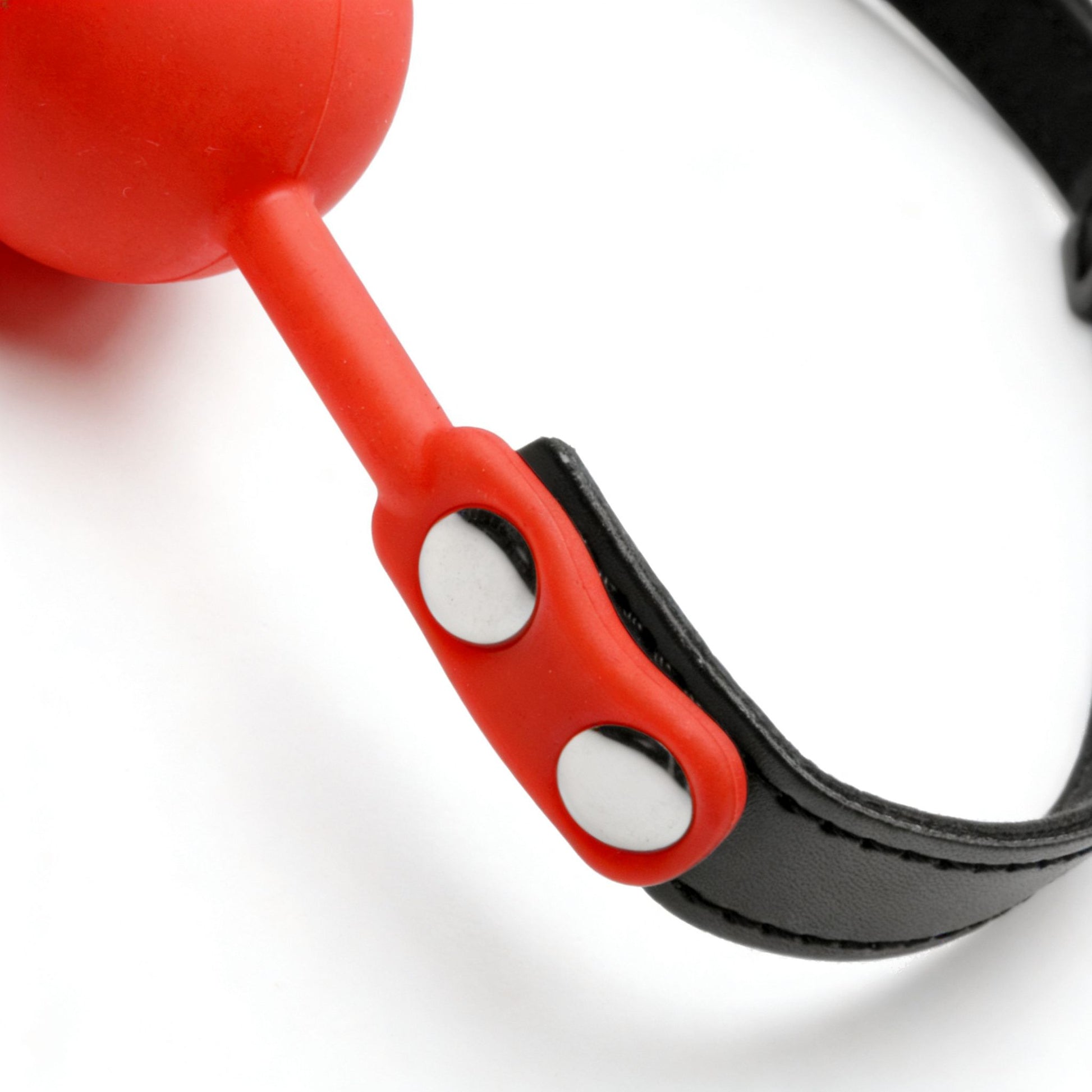 close-up of red silicone strap attachment with silver rivets on black adjustable gag strap