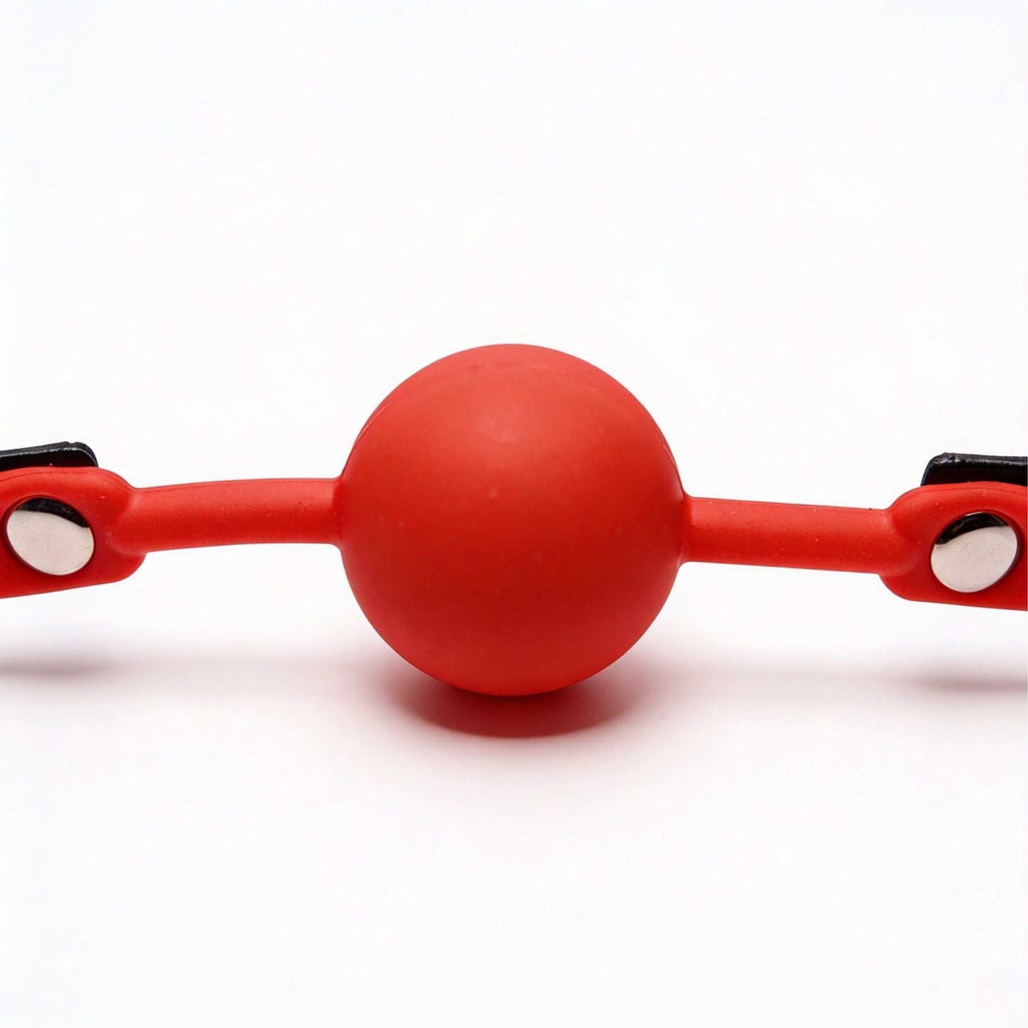 front close-up of red silicone ball gag with smooth round ball and flexible side straps