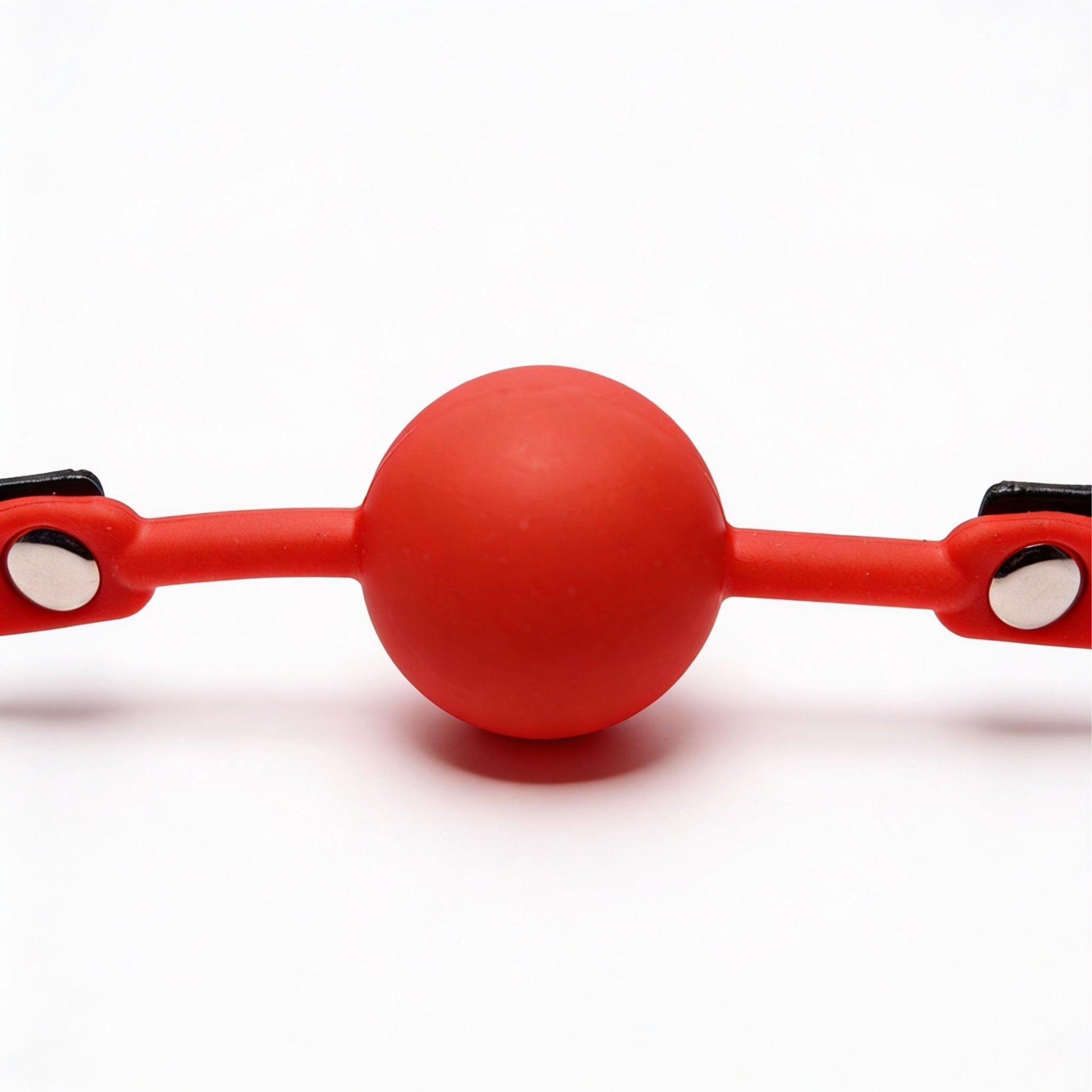 front close-up of red silicone ball gag with smooth round ball and flexible side straps