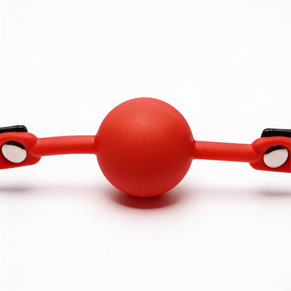 front close-up of red silicone ball gag with smooth round ball and flexible side straps