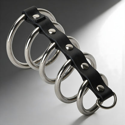 strict leather gates of hell cock cage with multiple stainless steel rings attached to black leather strap on clean background