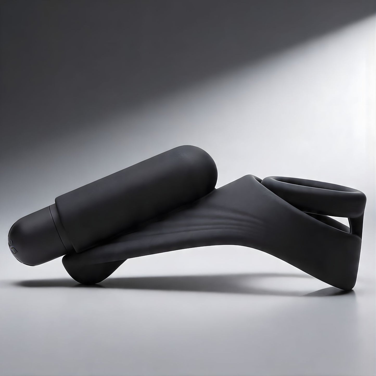 black silicone vibrating c-ring with attached bullet vibrator and curved perineum stimulator in side profile