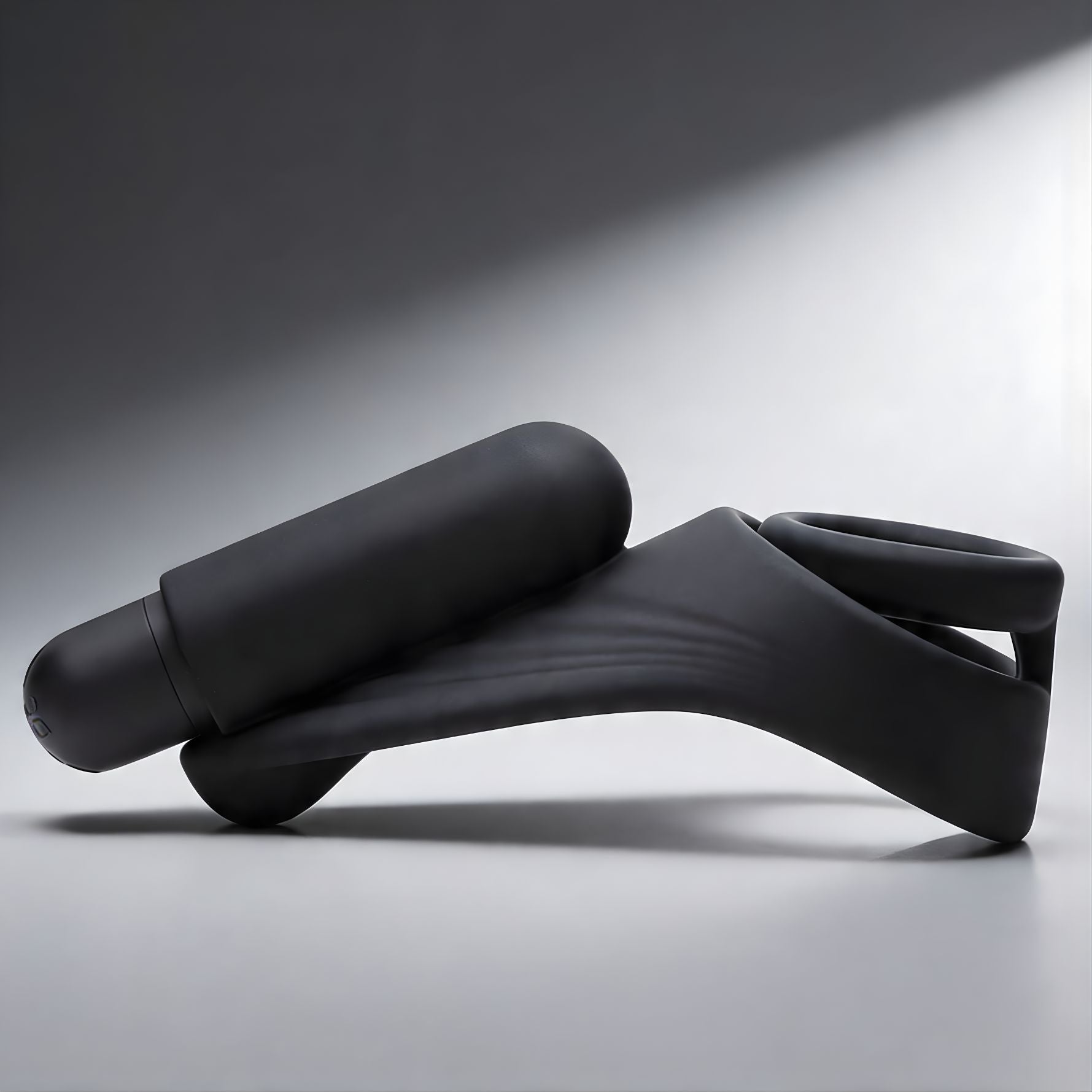 black silicone vibrating c-ring with attached bullet vibrator and curved perineum stimulator in side profile